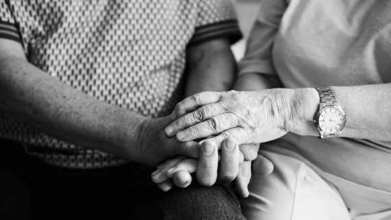 elderly people holding hands